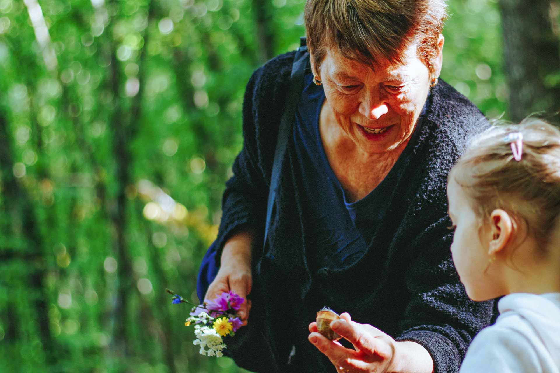 Woman and child looking at a flower.
